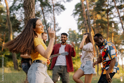 Multiracial group of people, beautiful hipster woman dancing on the background of friends having fun