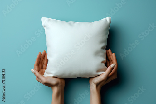 White blank square pillow mockup, woman holding with two hands on isolated pastel color background