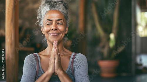 Mulher afro mais velha feliz fazendo yoga e meditação  photo