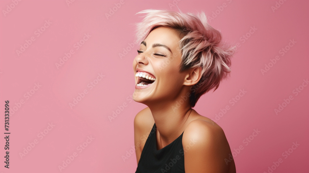 woman with short hair smiling and laughing on pink background