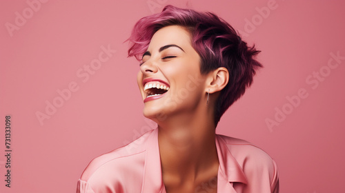woman with short hair smiling and laughing on pink background
