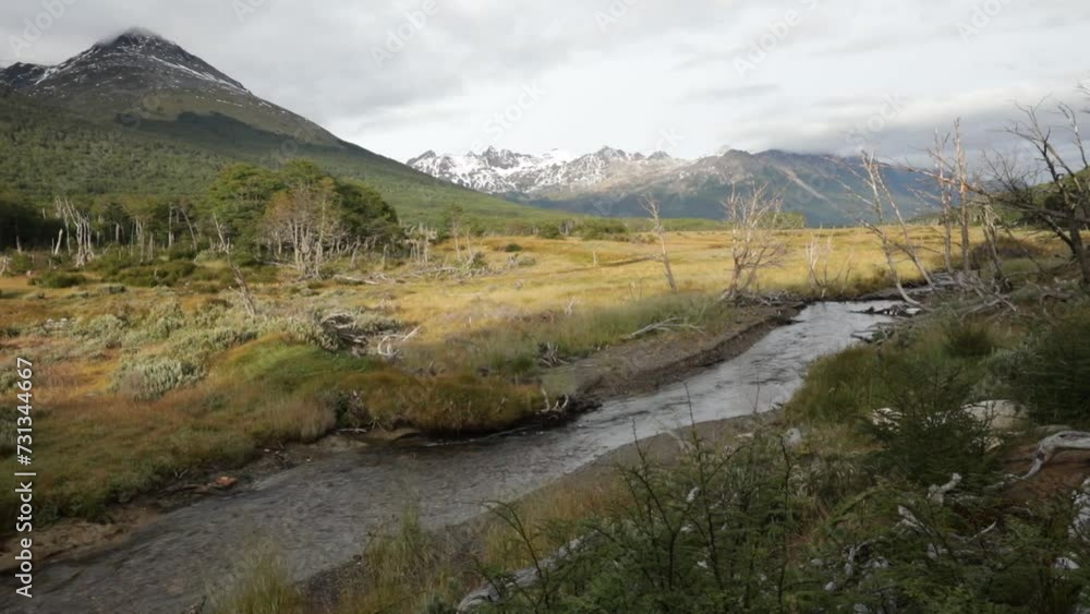 Panorama view of the river flowing across the yellow grassland and mountains in autumn Panorama view of the river flowing across the yellow grassland and mountains in autumn