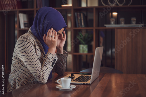 Muslim Business woman or female student with hijab under stress from too much work in the office photo