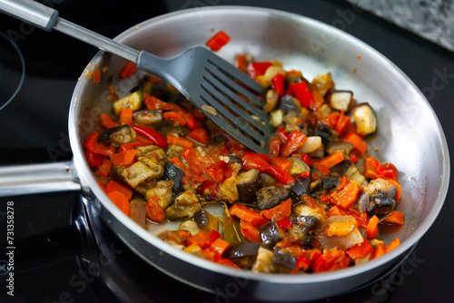 Roasted vegetables in a cast iron pan - carrot, onion, pepper