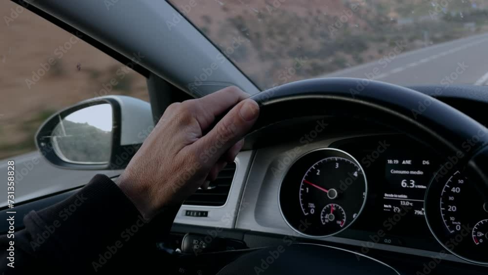 Close-up shot of hand driving a car showing the road
Close-up shot of hand driving a car showing the road