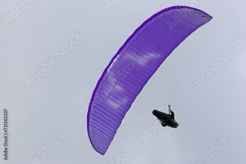 Paraglider flying in a cloudy sky	