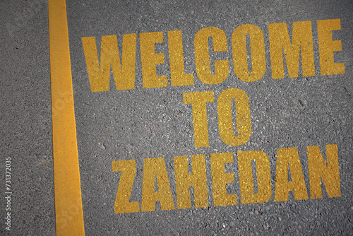 asphalt road with text welcome to Zahedan near yellow line. photo