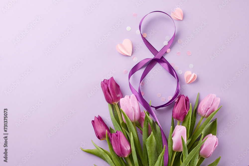 Honoring mothers and women: march 8th celebration in our community. Top view shot of 8-shaped ribbon, beautiful tulips, confetti, pink hearts on purple background with space for festive text Honoring mothers and women: march 8th celebration in our community. Top view shot of 8-shaped ribbon, beautiful tulips, confetti, pink hearts on purple background with space for festive text