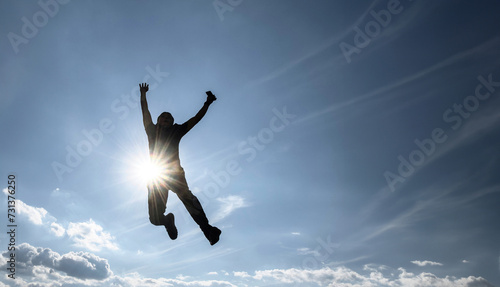 Man jumping with full sky background  sun rays  enjoying a moment of success  with space for text