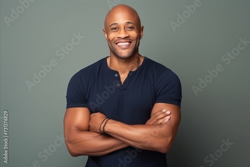 Portrait of a happy african american man with arms crossed against grey background