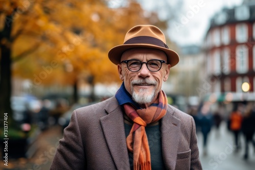 Portrait of a senior man in a hat and scarf in the city.