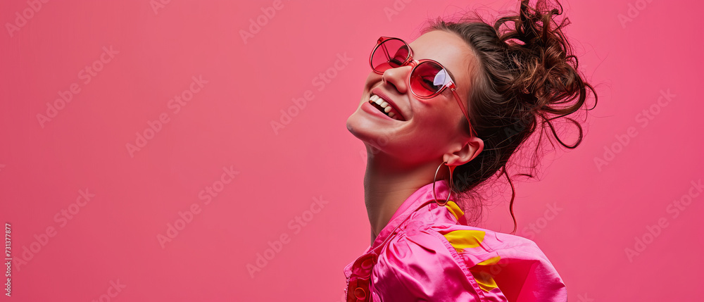 A woman wearing pink sunglasses and smiling with a vibrant pink hairpiece and bold lipstick strikes a pose in her statement sunglasses, exuding confidence and embracing her unique sense of style