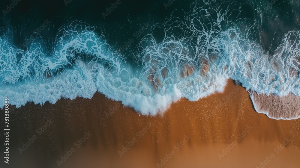 Fototapeta premium Drone shot of ocean waves crashing on a sandy shore