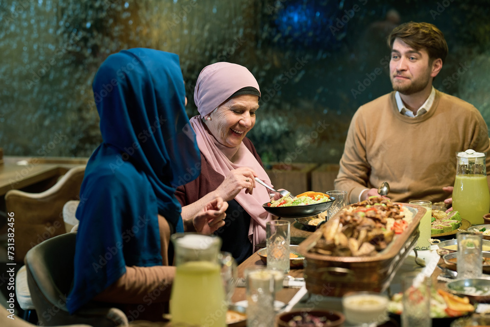 A modern and traditional European Islamic family comes together for iftar in a contemporary restaurant during the Ramadan fasting period, embodying cultural harmony and familial unity amidst a A modern and traditional European Islamic family comes together for iftar in a contemporary restaurant during the Ramadan fasting period, embodying cultural harmony and familial unity amidst a