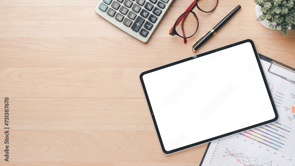 Tablet with charts and reports on office desk workplace. Top view flat lay Tablet with charts and reports on office desk workplace. Top view flat lay