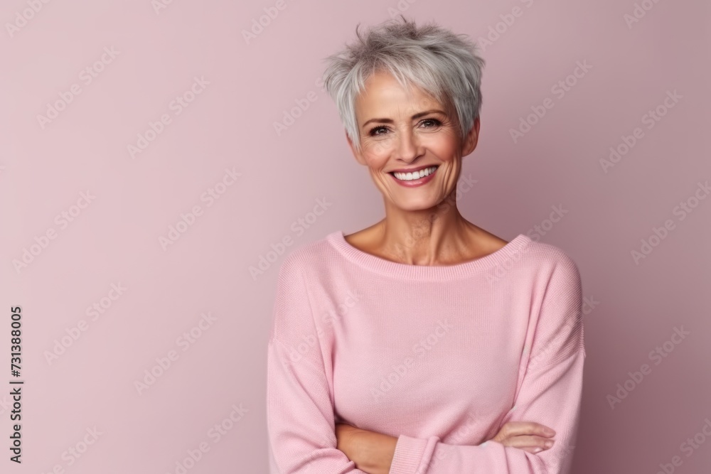Portrait of a happy senior woman smiling at the camera over pink background Portrait of a happy senior woman smiling at the camera over pink background