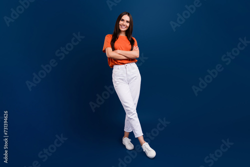 Full length photo of confident adorable lady wear orange t-shirt arms crossed isolated dark blue color background © deagreez