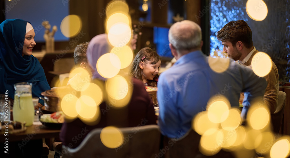 Fototapeta premium A modern and traditional European Islamic family comes together for iftar in a contemporary restaurant during the Ramadan fasting period, embodying cultural harmony and familial unity amidst a