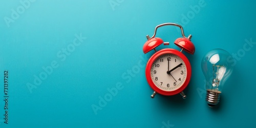 Red alarm clock with light bulb on blue background with copy space, idea and creativity concept