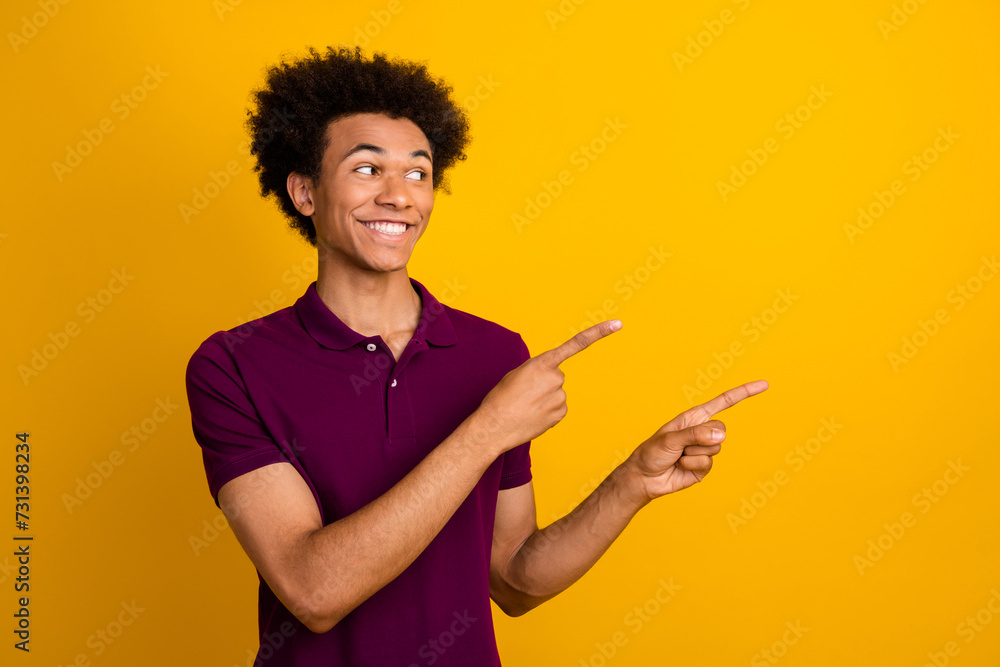 Photo of positive nice man wear trendy violet clothes two arms presents empty space introduces benefit isolated on yellow color background