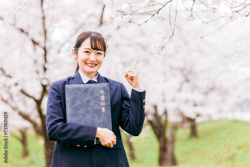 満開の桜の下で卒業証書を持つ高校生・女子高生（卒業生・卒業式・卒業） 
