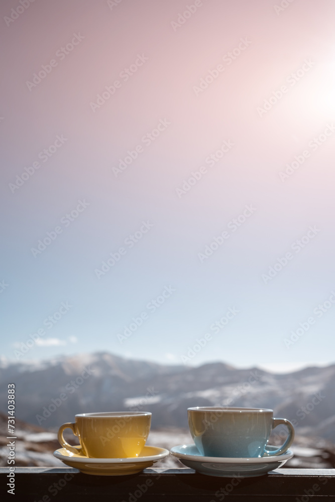 two hot coffee or tea cup outdoor on nature background, winter mountains and sky