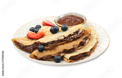 Tasty crepes with chocolate paste and berries isolated on white
