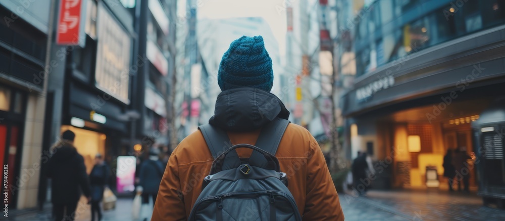 A fictional character wearing a hat and a electric blue backpack travels down a city street, amidst pedestrians on a bustling road. A fictional character wearing a hat and a electric blue backpack travels down a city street, amidst pedestrians on a bustling road.