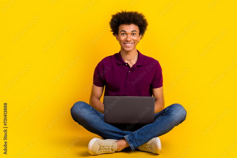 Photo of cheerful glad man wear stylish magenta clothes sit floor modern netbook wifi connection isolated on yellow color background