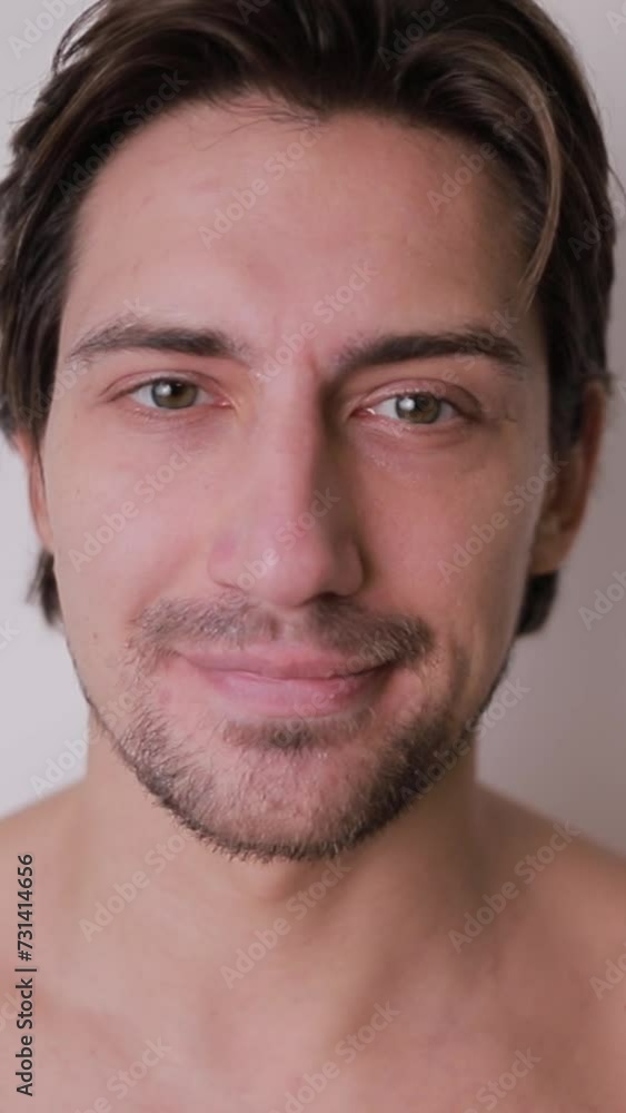 A shirtless man with a beard is smiling for the camera A shirtless man with a beard is smiling for the camera