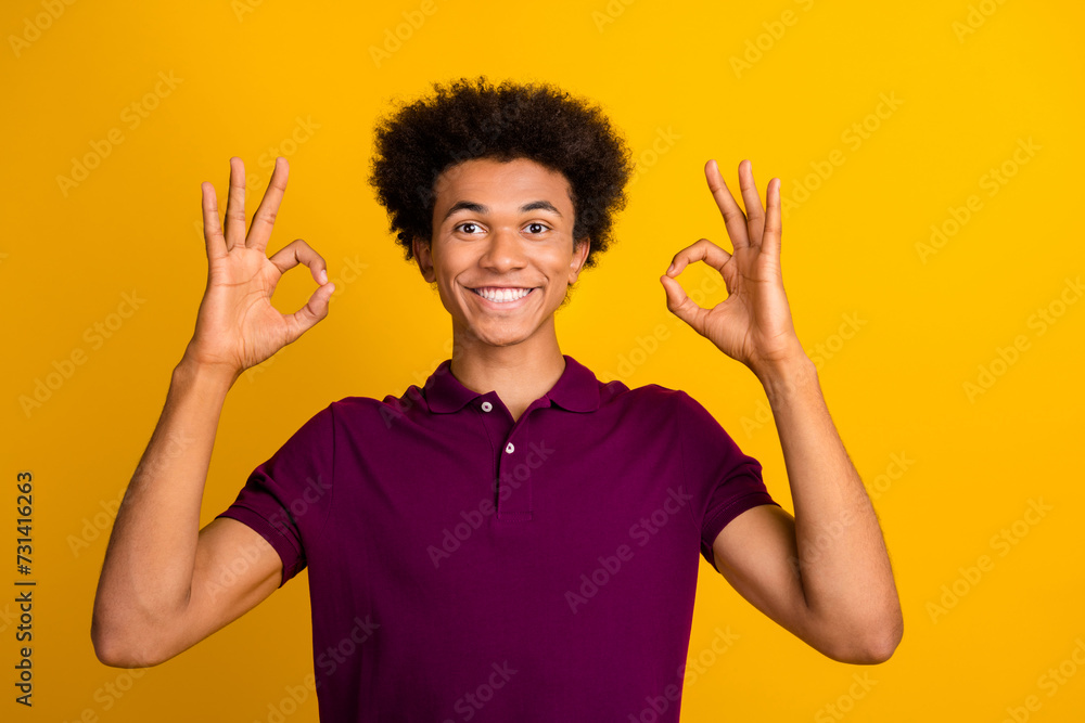 Photo of cheerful satisfied guy wear stylish violet clothes demonstrate two okey symbols isolated on yellow color background Photo of cheerful satisfied guy wear stylish violet clothes demonstrate two okey symbols isolated on yellow color background