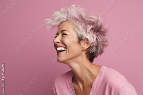 Portrait of a happy senior woman with pink hair on a pink background