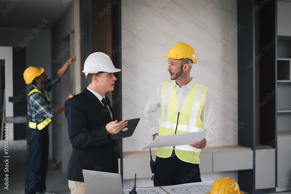 professional engineers in safety vests and hardhats working with blueprints and showing construction, Industrial engineers in hard hat discuss new project, they work in manufacturing factory. professional engineers in safety vests and hardhats working with blueprints and showing construction, Industrial engineers in hard hat discuss new project, they work in manufacturing factory.