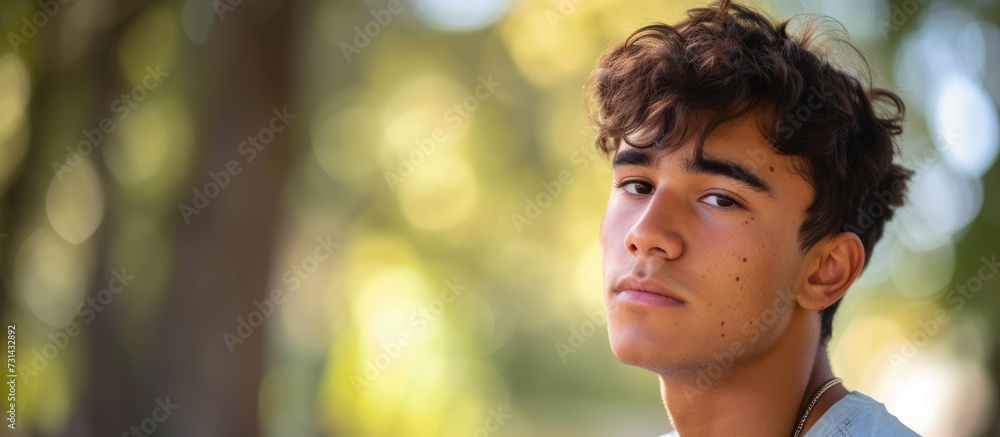 A young man's joyful smile and expressive gestures captivate the camera while he stands beside a tree, embodying the harmony between humans and nature in a captivating portrait. A young man's joyful smile and expressive gestures captivate the camera while he stands beside a tree, embodying the harmony between humans and nature in a captivating portrait.