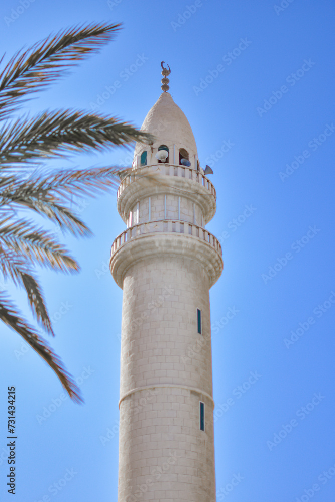 Minaret of a Muslim mosque over the blue sky, Aqaba, Jordan.
