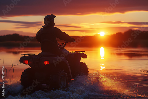 Silhouette shot of atv rider with river and sunset in the background.
