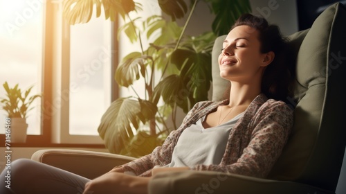 A Happy woman sitting in comfortable chair in home design, relaxing, breathing fresh air. A smiling young female tenant or a tenant relaxing in an armchair relieves negative emotions