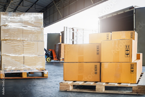 Package Boxes Stack on Wooden Pallets Loading into Container Trucks. Distribution Supplies Warehouse Shipping. Supply Chain, Shipment. Freight Truck Logistics Transport.