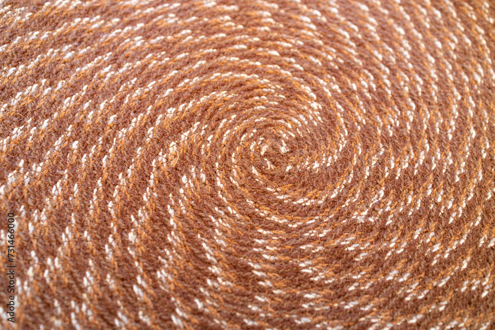 Fototapeta premium Macro abstract texture background of a circular pattern woven fabric placemat in colors of brown and white 
