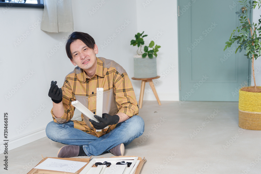 家具を組み立てる中年男性 家具を組み立てる中年男性