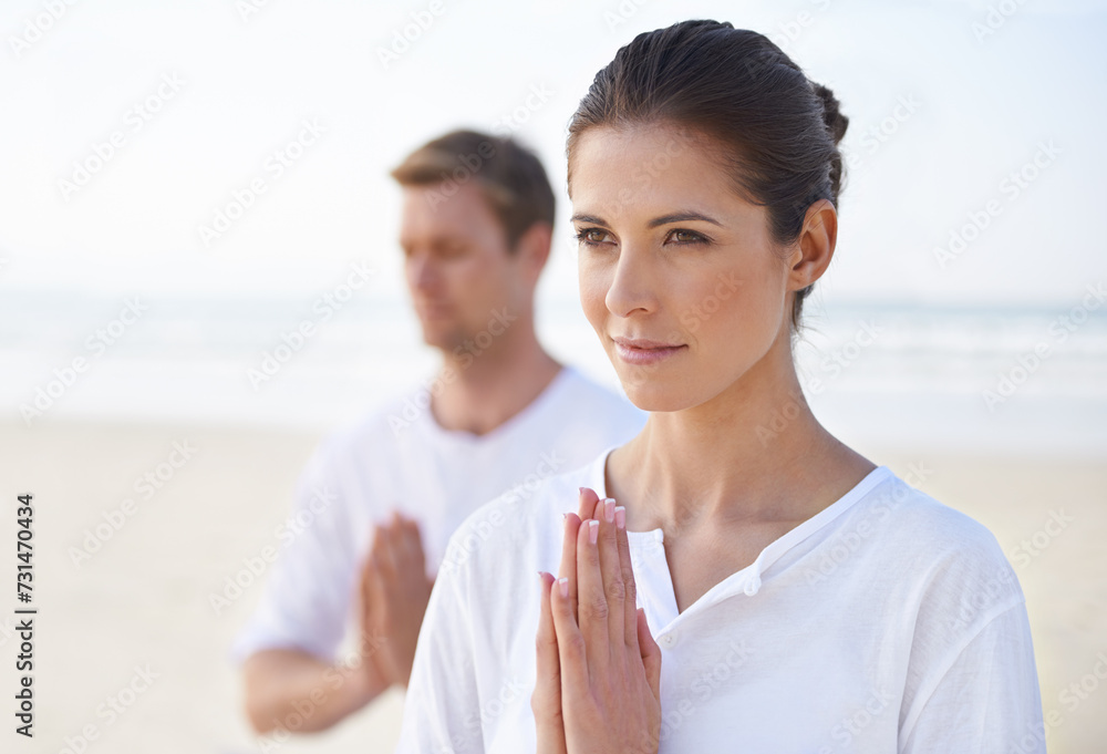 Obraz premium Meditation, yoga and couple on beach in morning for fitness, exercise and mindfulness. Nature, love and man and woman by ocean with prayer hands for calm, wellness and healthy body outdoors together