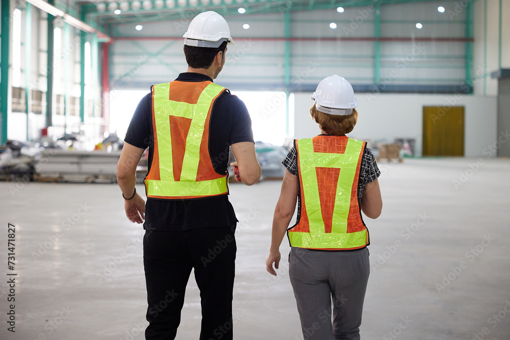 back view factory workers walking and talking about work or project in the warehouse storage back view factory workers walking and talking about work or project in the warehouse storage