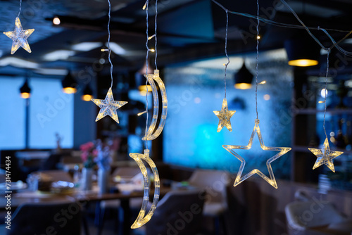 In a modern restaurant, the ambiance is transformed by the presence of sparkling Islamic symbolic Ramadan decorations, creating a festive and culturally rich atmosphere