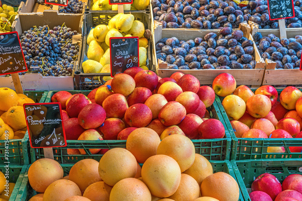 Oranges, apples and plums for sale at a market
