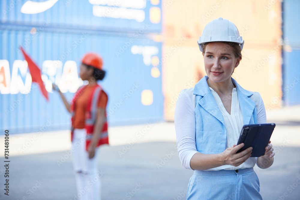 businesswoman wearing safety helmet and working on tablet in containers warehouse storage businesswoman wearing safety helmet and working on tablet in containers warehouse storage