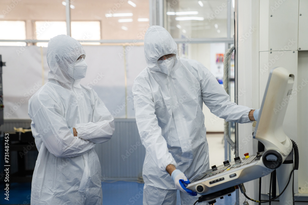 Professional Heavy Industry Robotics Engineer Wearing White Coat Holding Tablet Computer Works in Laboratory. Facility Full of Computers, control robot. Professional Heavy Industry Robotics Engineer Wearing White Coat Holding Tablet Computer Works in Laboratory. Facility Full of Computers, control robot.