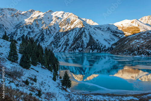 Mountain lake in the vicinity of the Kazakh city of Almaty and snow-covered mountains in the early morning