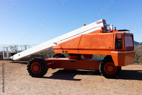 Telescopic Boom Lift For Construction, Painting, Electrical Work And Industrial Maintenance. Truck, Blue Sky On Background. Manlifting Cranes. Self Propelled Wheeled Hydraulic Articulated Boom Lift.  photo