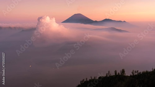 4k Timelapse Movie Sunrise Scene of Moving Cloud, Fog and Smoke of Eruption Cover Volcano Mts. Bromo, Semeru, Batok and Widodaren, Tengger Caldera, Indonesia photo