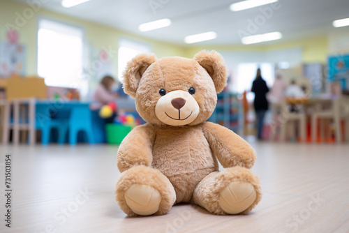 Children day care center, kindergarten or preschool with teddy bear and blurry playing children in background